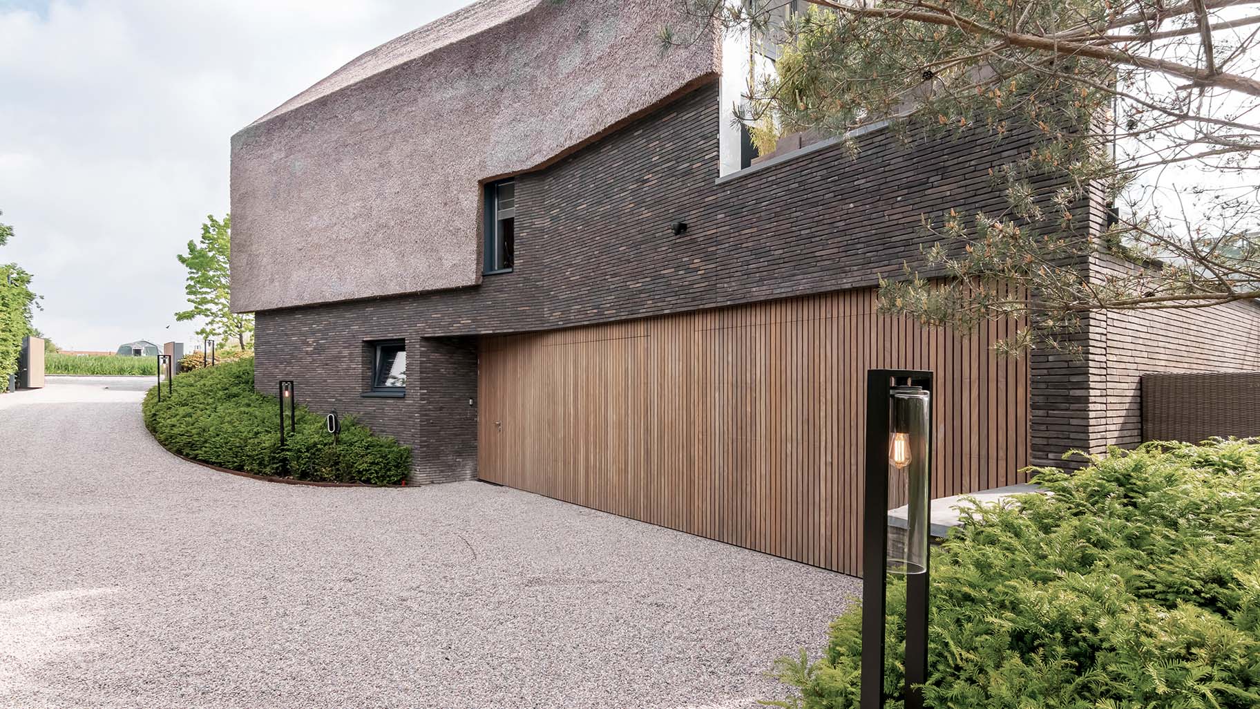 Afrormosia houten garagedeuren en loopdeur gelijk met de gevel