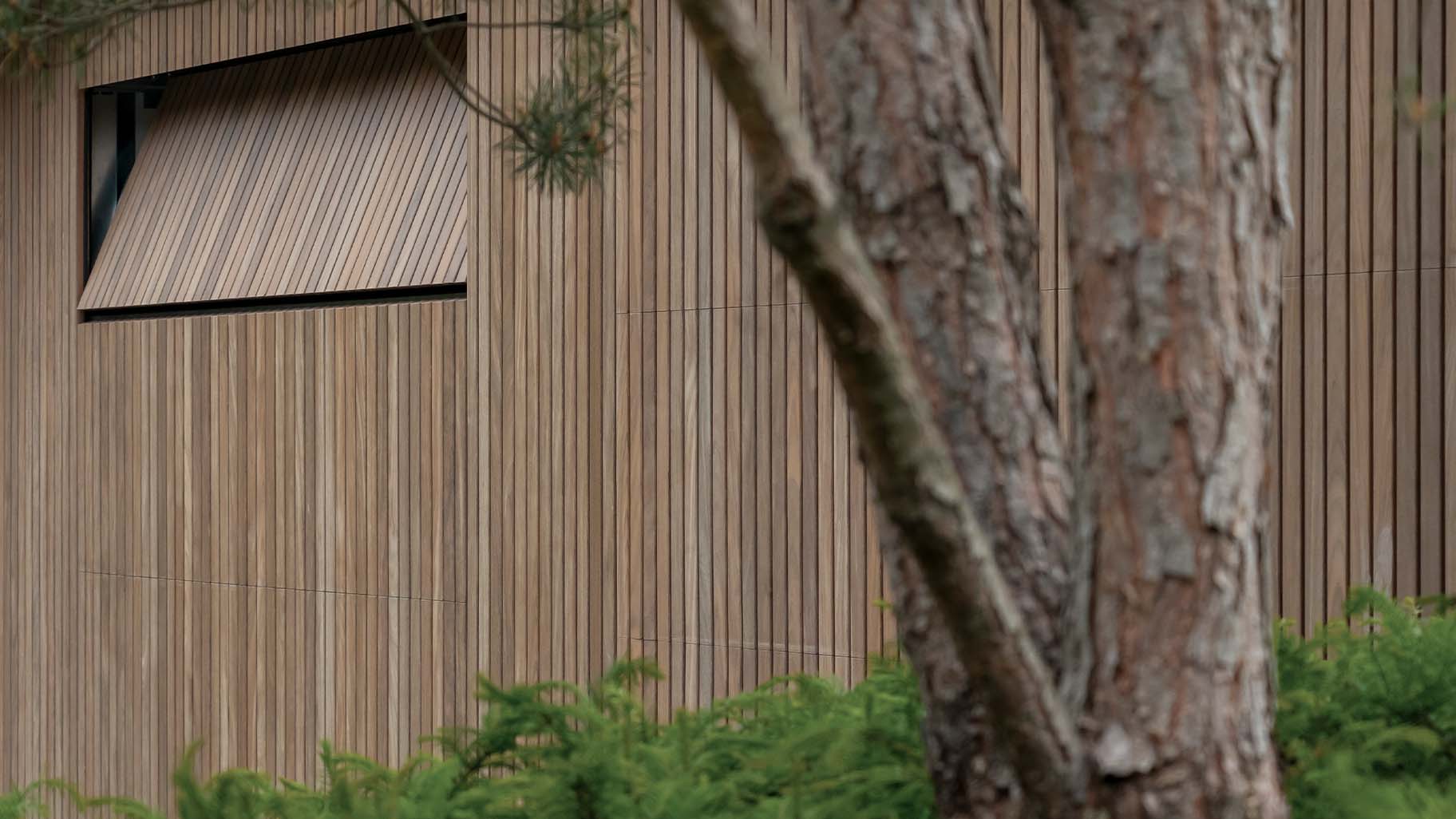 Afrormosia houten garagedeuren en loopdeur gelijk met de gevel