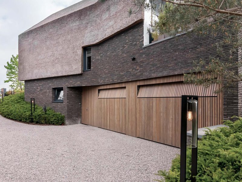 Afrormosia houten garagedeuren en loopdeur gelijk met de gevel