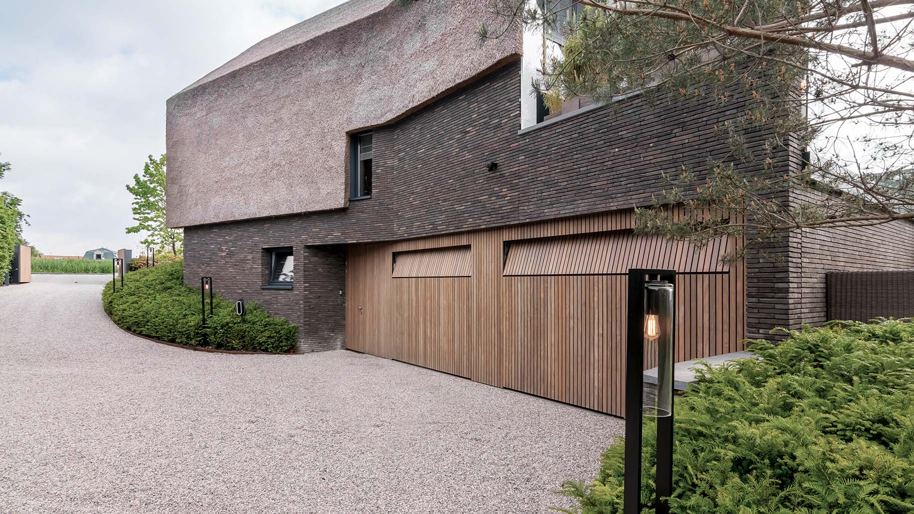 Afrormosia houten garagedeuren en loopdeur gelijk met de gevel