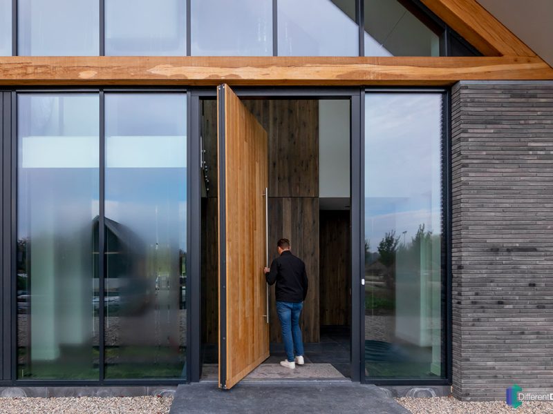 Moderne villa met hoge houten taatsdeur als opvallende voordeur