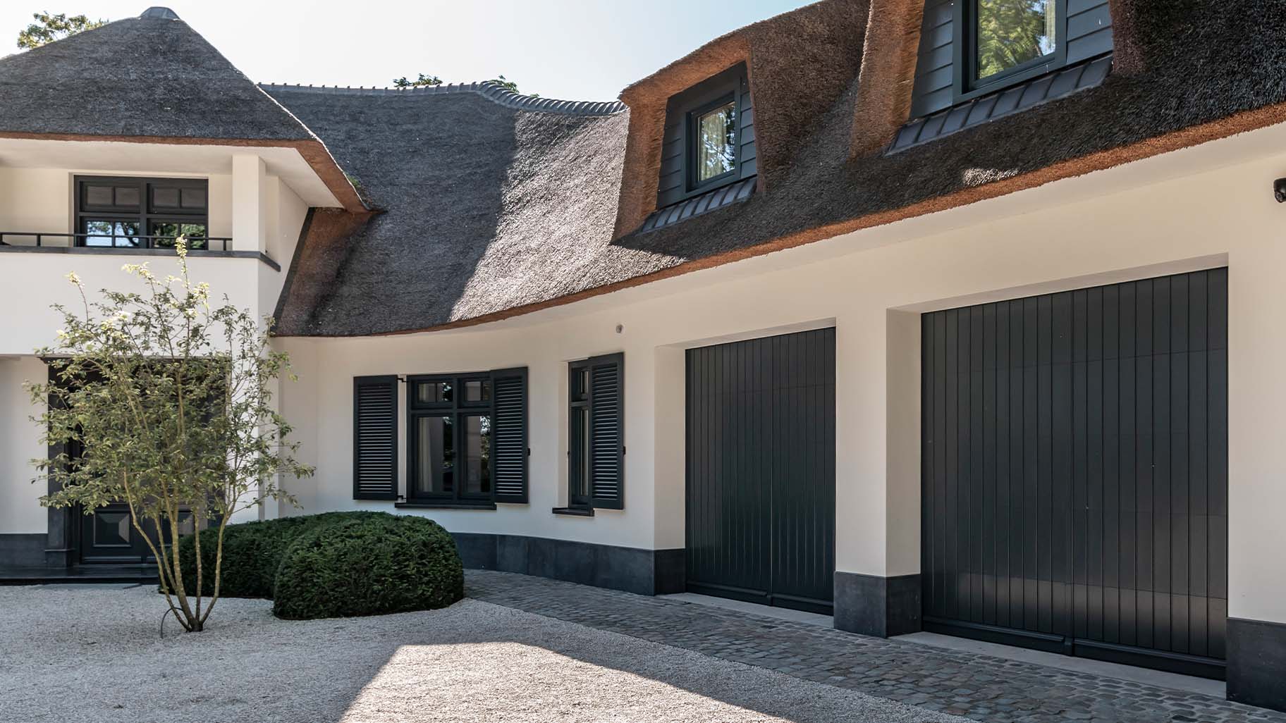 Twee op maat gemaakte houten sectionaaldeuren in authentieke stijl, afgewerkt in RAL7016 antracietgrijs