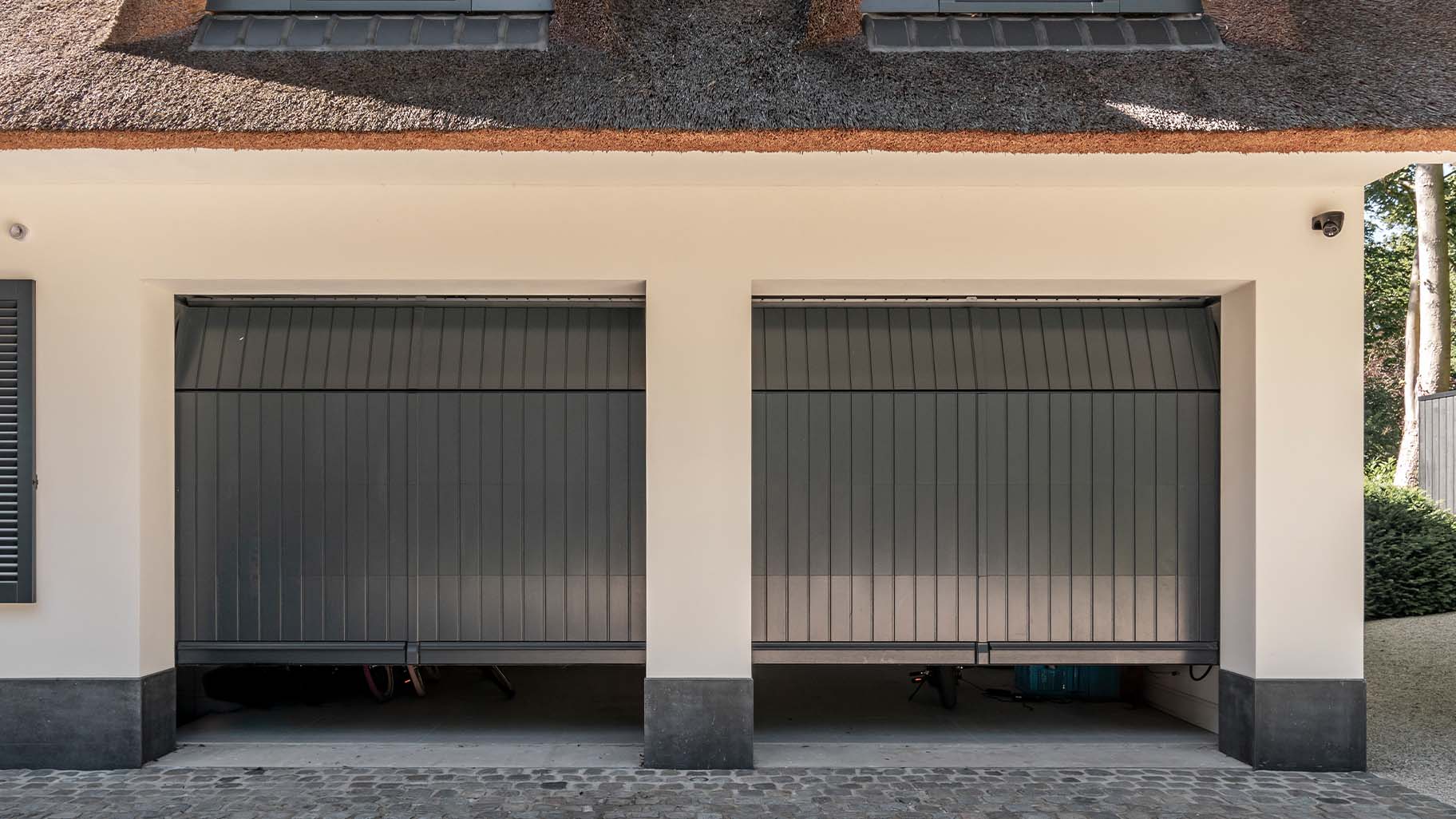 Twee op maat gemaakte houten sectionaaldeuren in authentieke stijl, afgewerkt in RAL7016 antracietgrijs