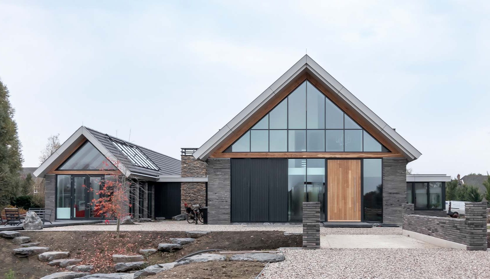 Moderne villa met hoge houten taatsdeur als opvallende voordeur