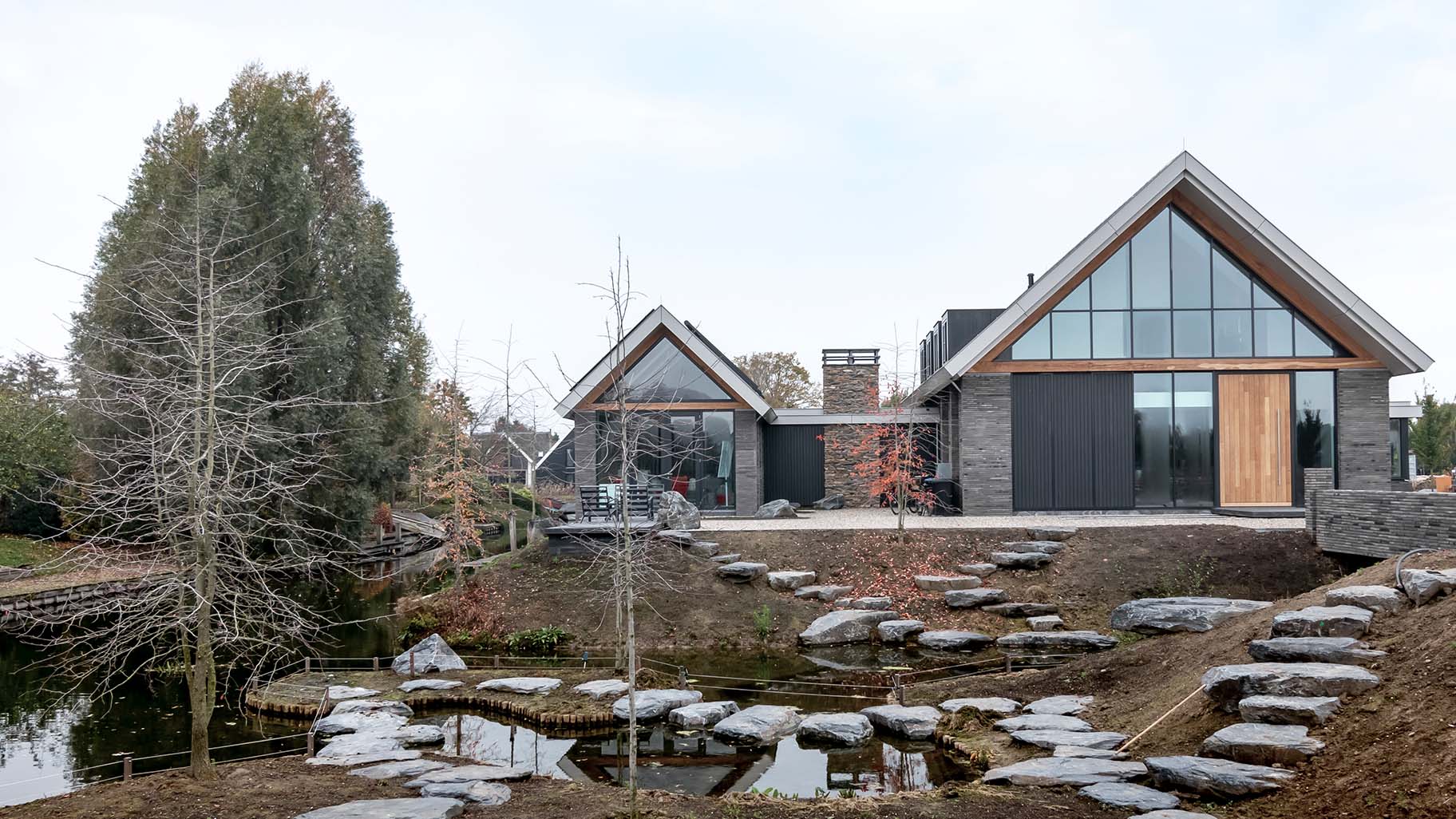 Vrijstaande woning met hoge houten taatsdeur als opvallende voordeur