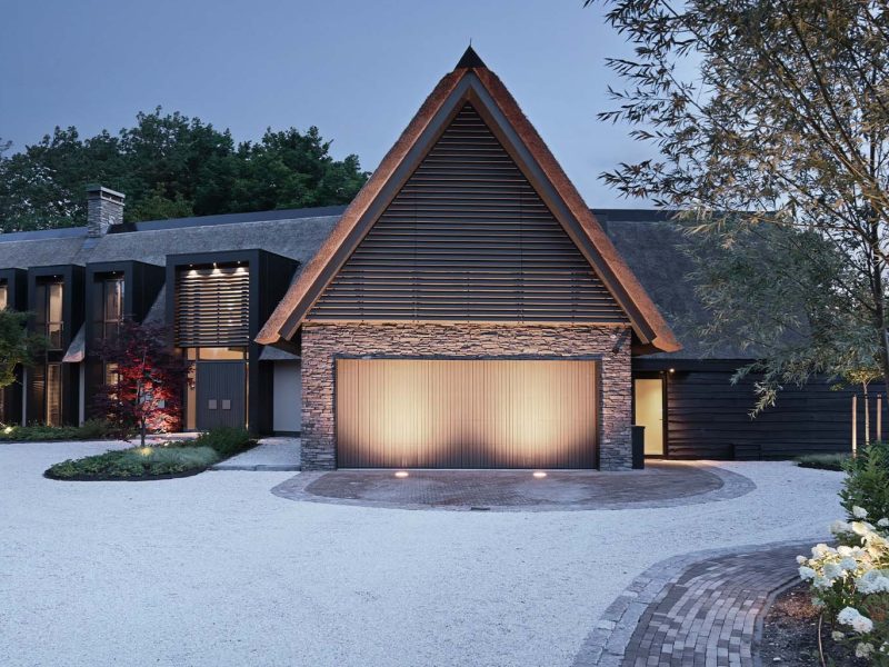 "Different Doors Red Cedar houten garagedeur bij high-end moderne villa met rieten kap