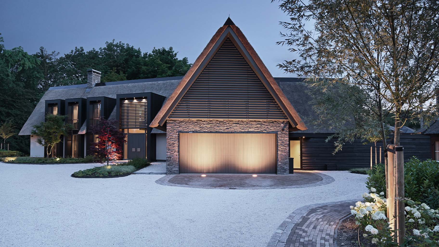 "Different Doors Red Cedar houten garagedeur bij high-end moderne villa met rieten kap