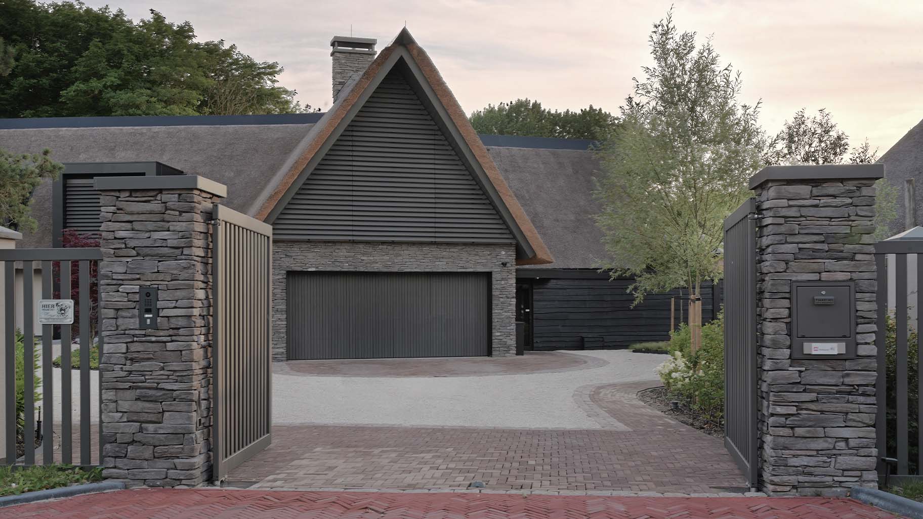"Red Cedar houten garagedeur achter de dag gemonteerd, naadloos geïntegreerd in moderne villa