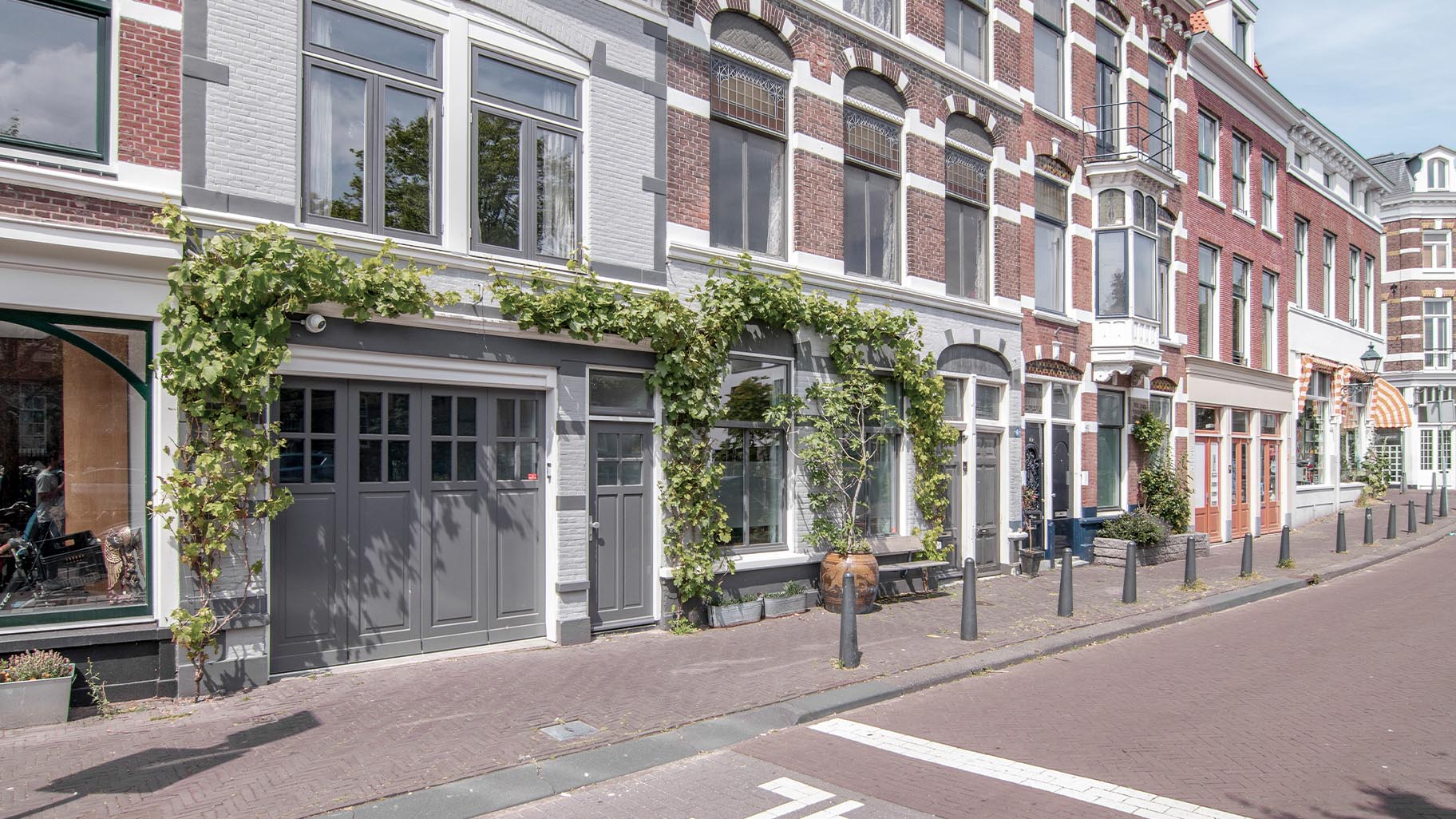 Een door Different Doors op maat gemaakte zijwaartse garagedeur, ontworpen om de klassieke esthetiek van deze monumentale woning