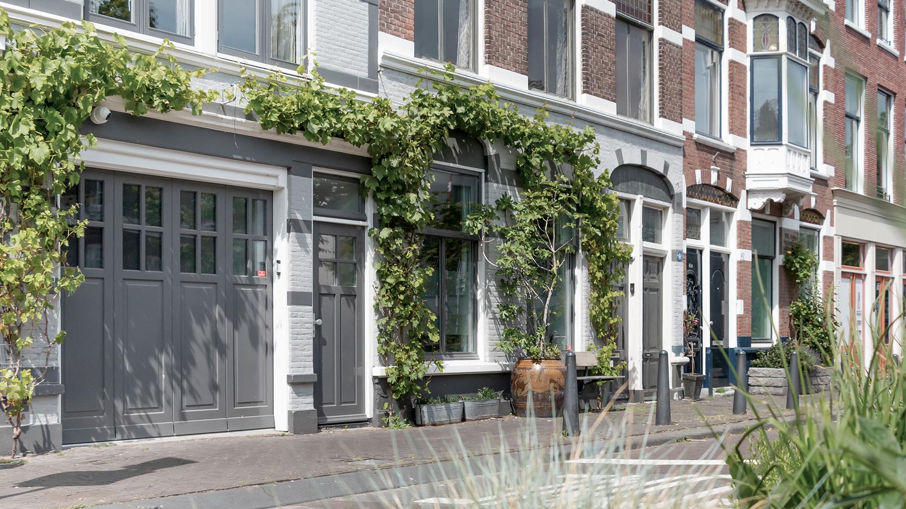 Een door Different Doors op maat gemaakte zijwaartse garagedeur, ontworpen om de klassieke esthetiek van deze monumentale woning