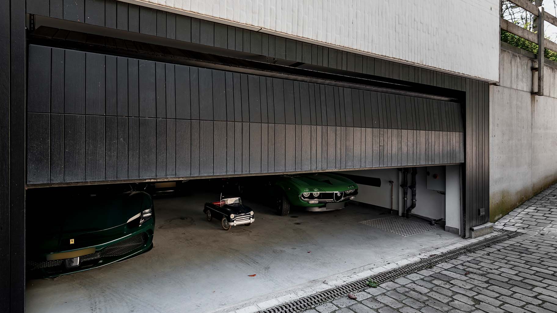 Donkere houten garagedeur gelijk in de gevel