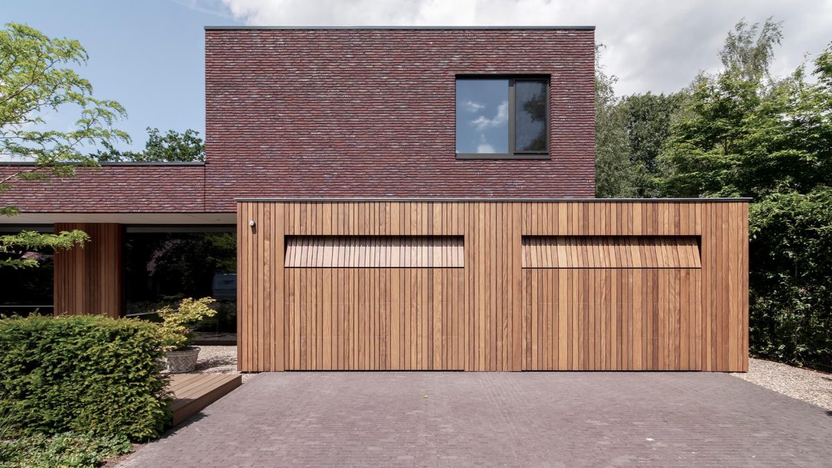 Moderne woning met dubbele houten sectionaaldeuren die bijdragen aan een stijlvolle uitstraling