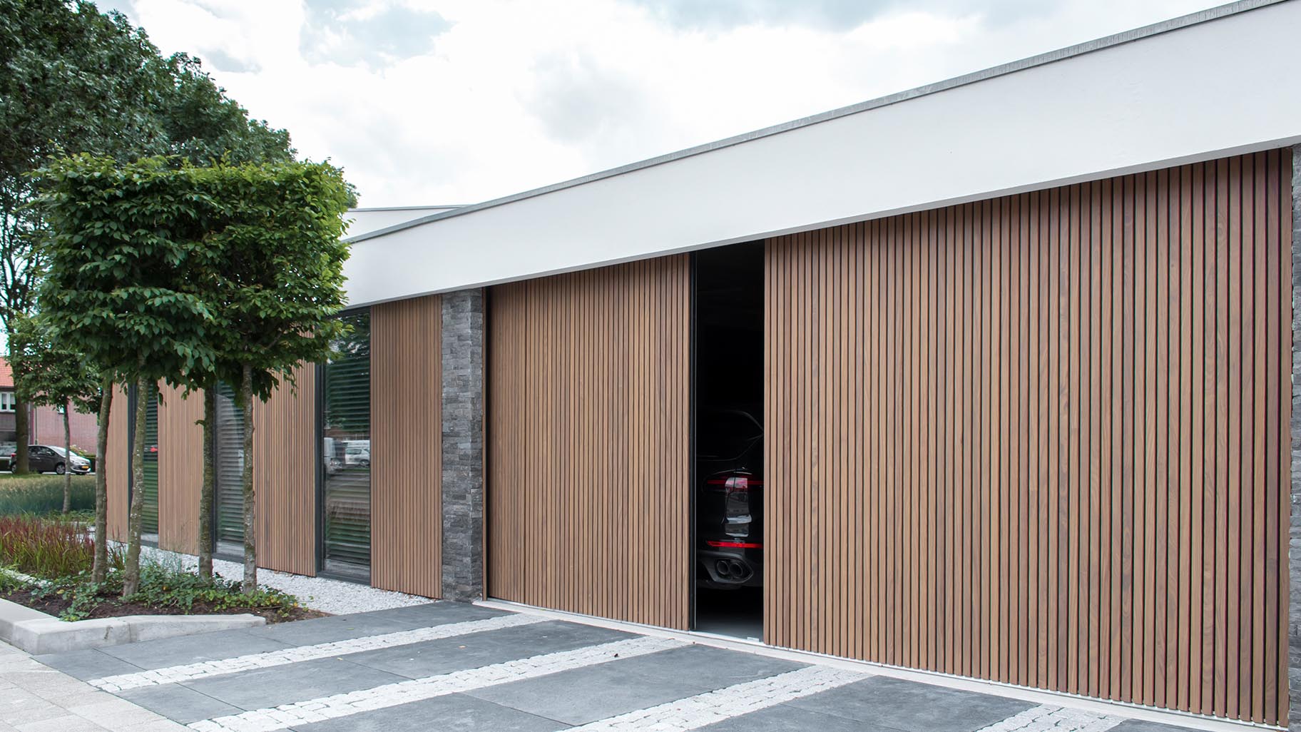 Dubbele houten zijwaartse garagedeur van afrormosia latten - Different Doors