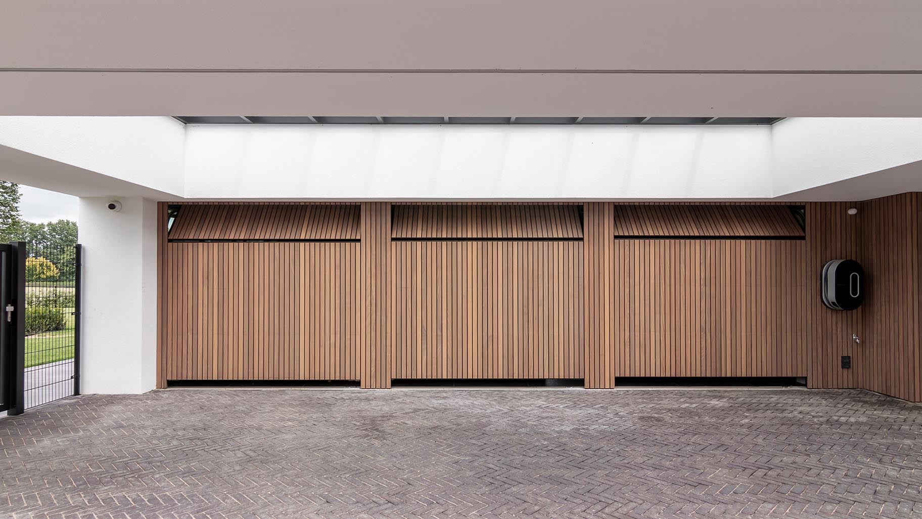Meerdere garagedeuren geïntegreerd in de gevel van een exclusieve villa voor een stijlvolle uitstraling