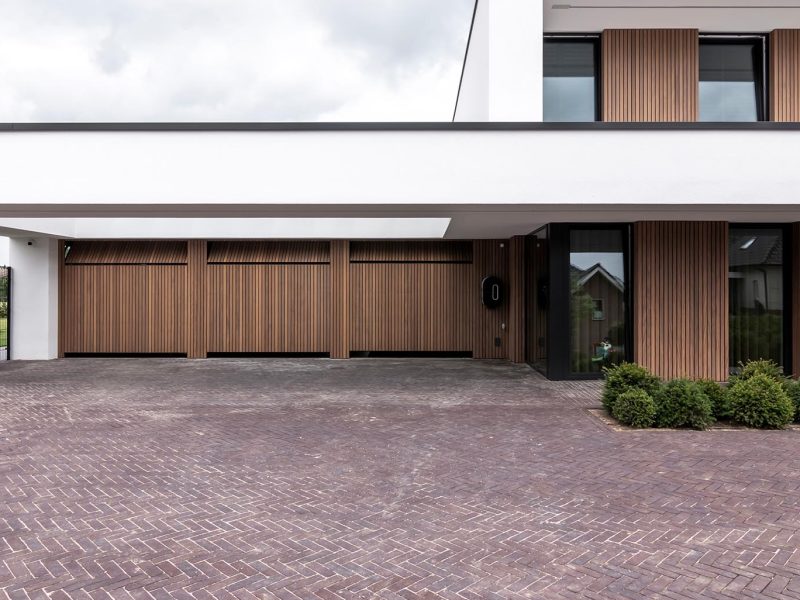 Meerdere garagedeuren geïntegreerd in de gevel van een exclusieve villa voor een stijlvolle uitstraling