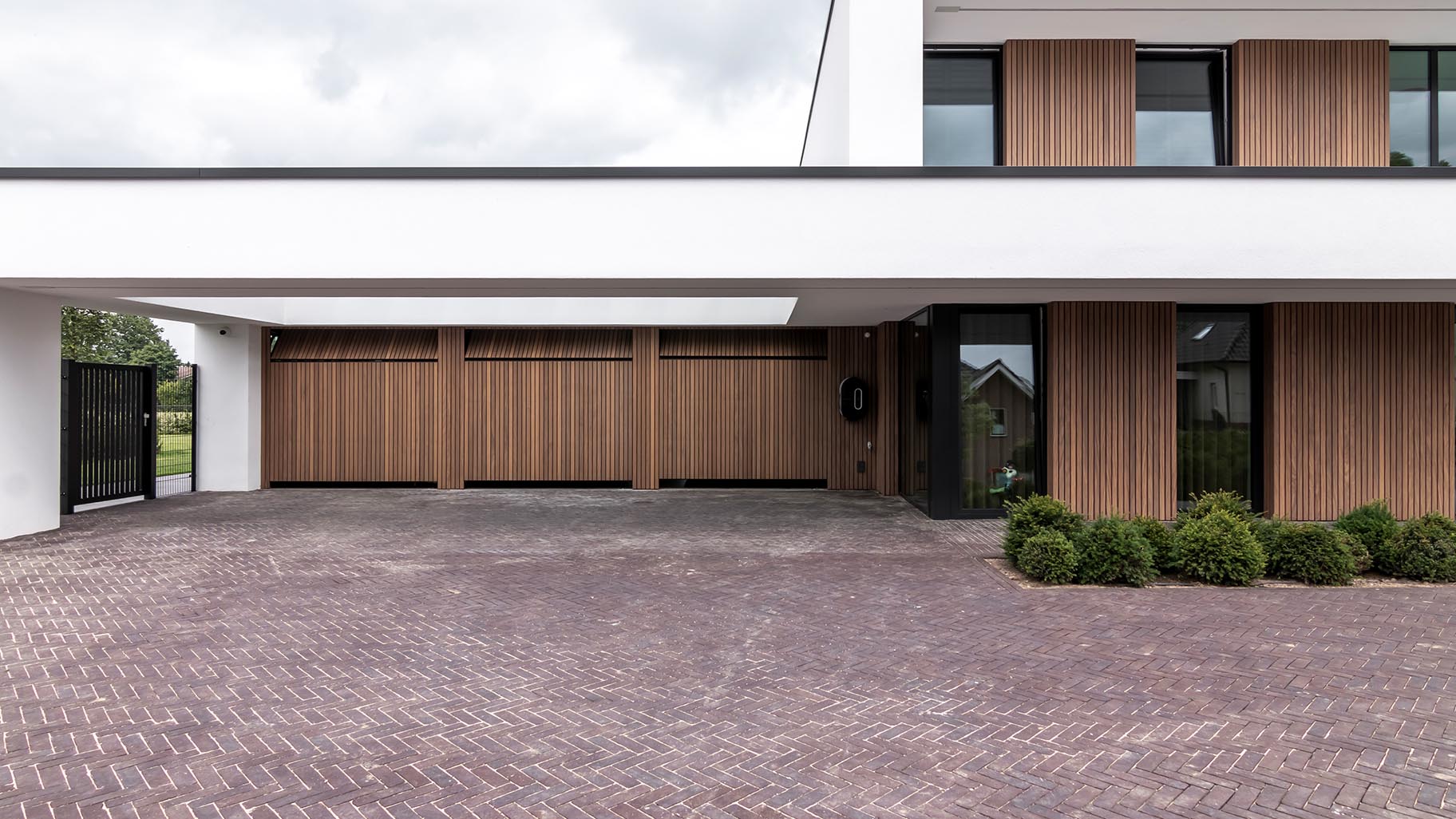 Meerdere garagedeuren geïntegreerd in de gevel van een exclusieve villa voor een stijlvolle uitstraling