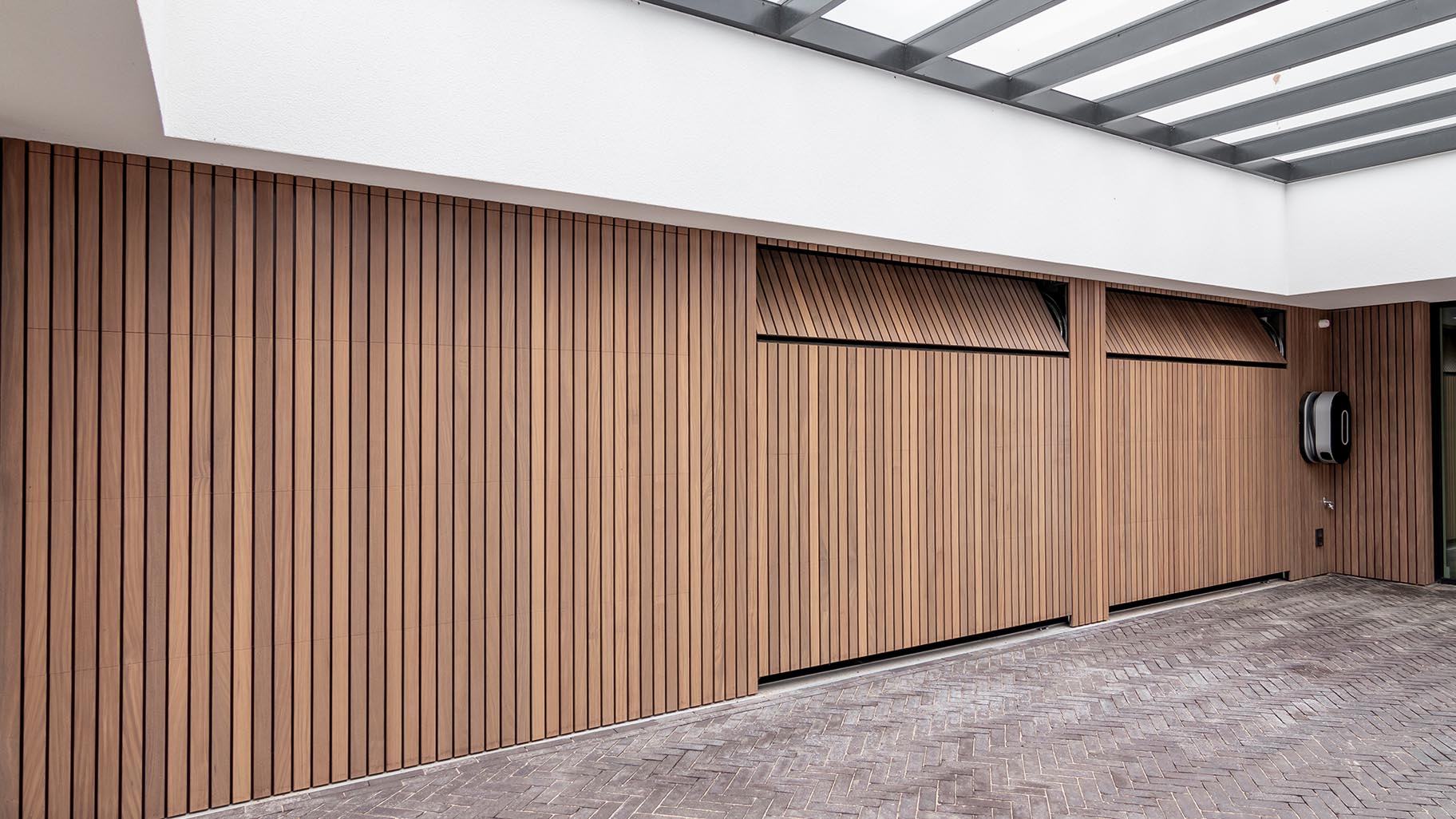 Exclusieve villa met drie garagedeuren verborgen in de gevel voor een onopvallende uitstraling