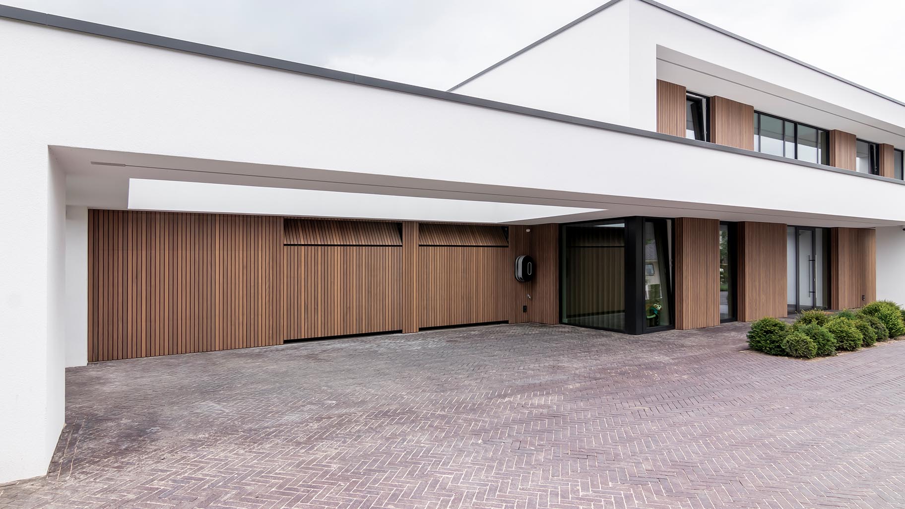 Exclusieve villa met drie garagedeuren verborgen in de gevel voor een onopvallende uitstraling