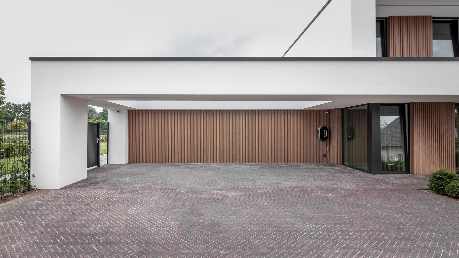 Exclusieve villa met meerdere garagedeuren die de moderne architectuur en luxe van het huis benadrukken