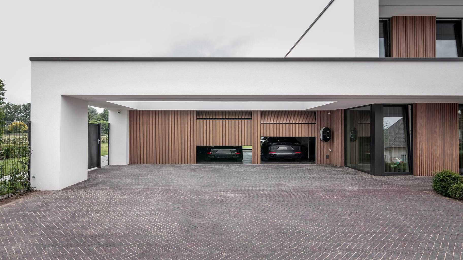 Meerdere garagedeuren geïntegreerd in de gevel van een exclusieve villa voor een stijlvolle uitstraling