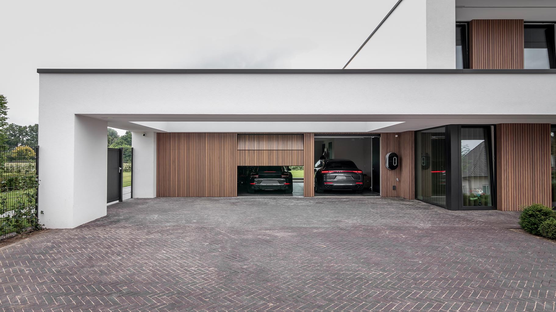Meerdere garagedeuren geïntegreerd in de gevel van een exclusieve villa voor een stijlvolle uitstraling