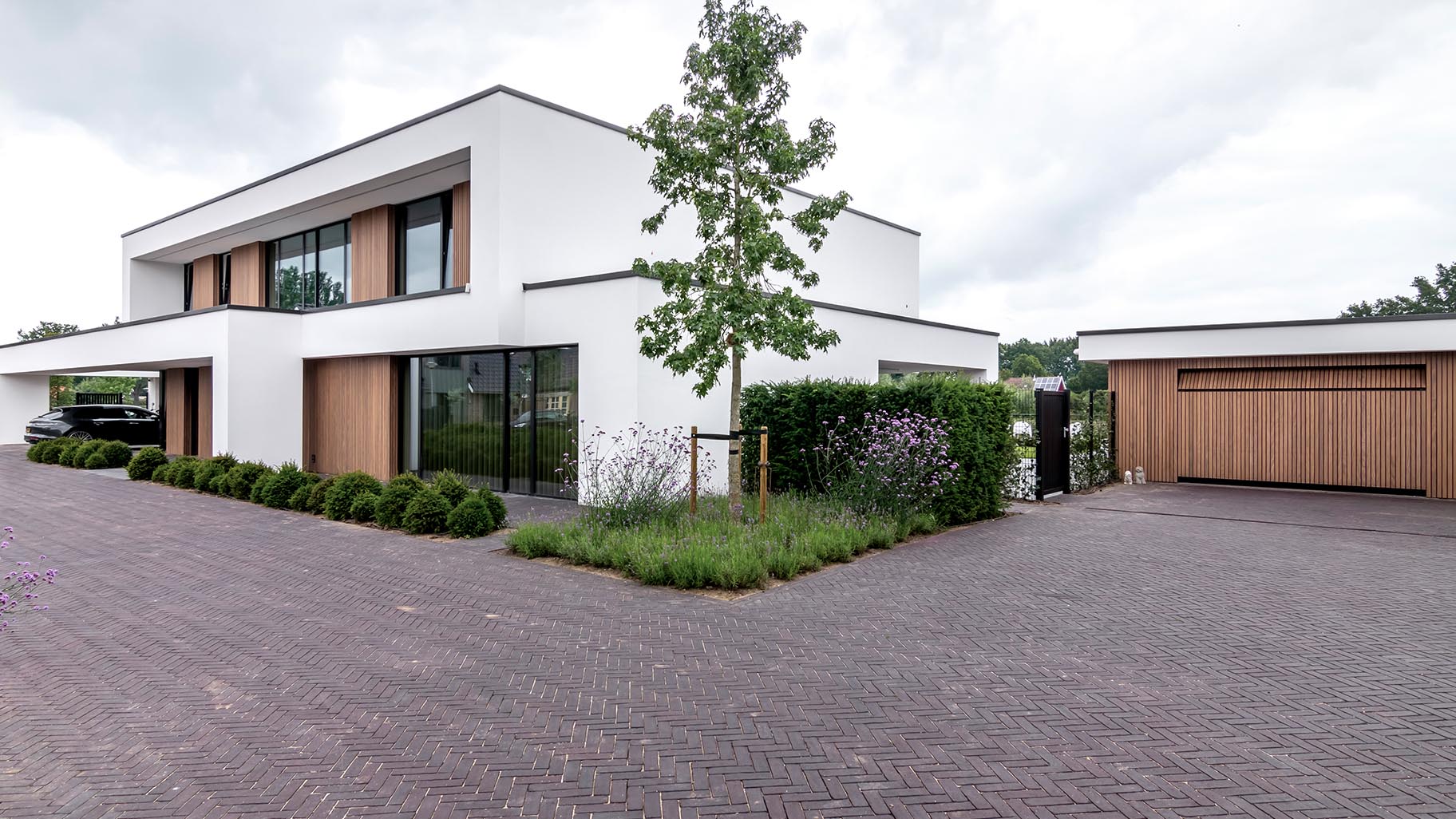 Exclusieve villa met meerdere garagedeuren die de moderne architectuur en luxe van het huis benadrukken