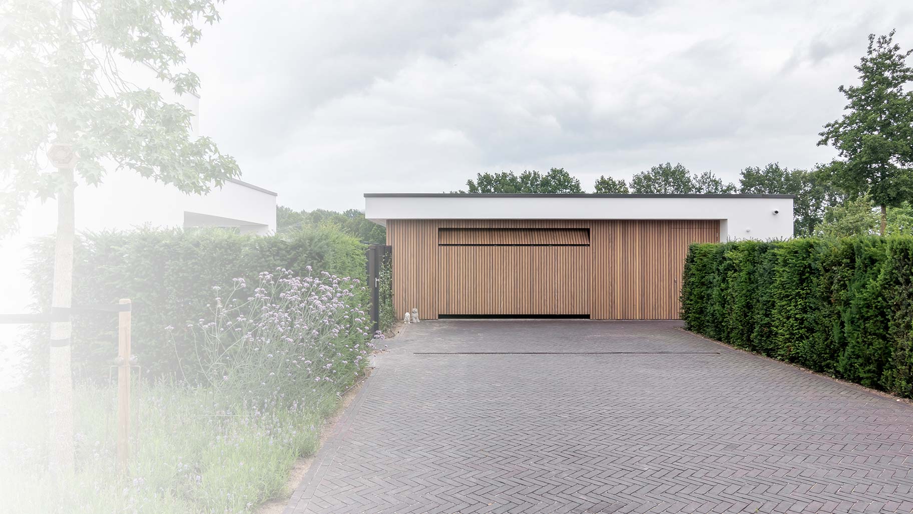 Garagedeuren perfect verborgen in de gevel van een exclusieve villa voor een naadloze look