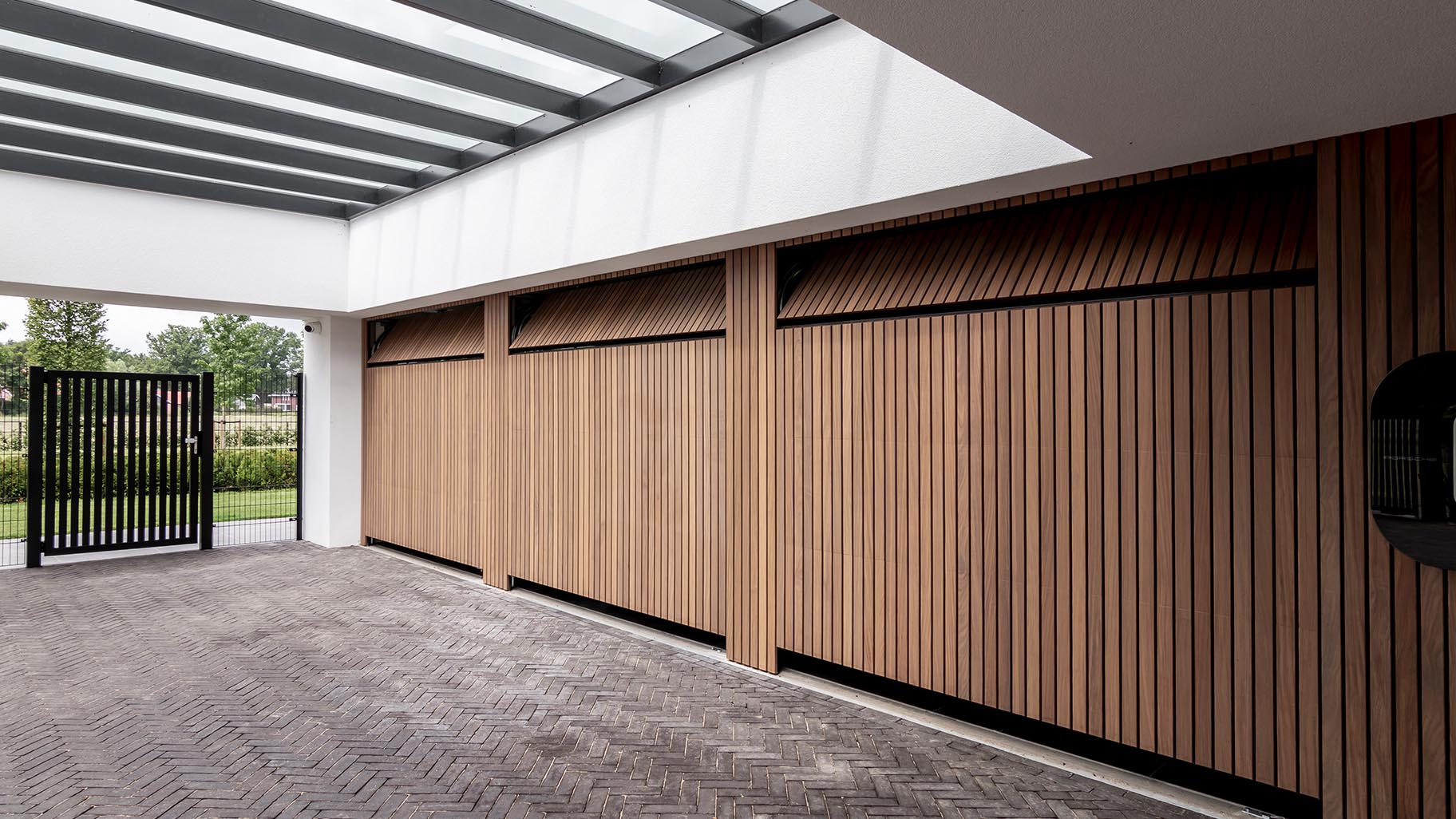 Exclusieve villa met drie garagedeuren verborgen in de gevel voor een onopvallende uitstraling