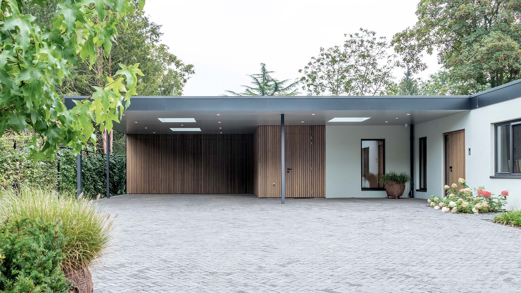 Different Doors garagedeur en voordeur van Frake hout, geïntegreerd in moderne gevel