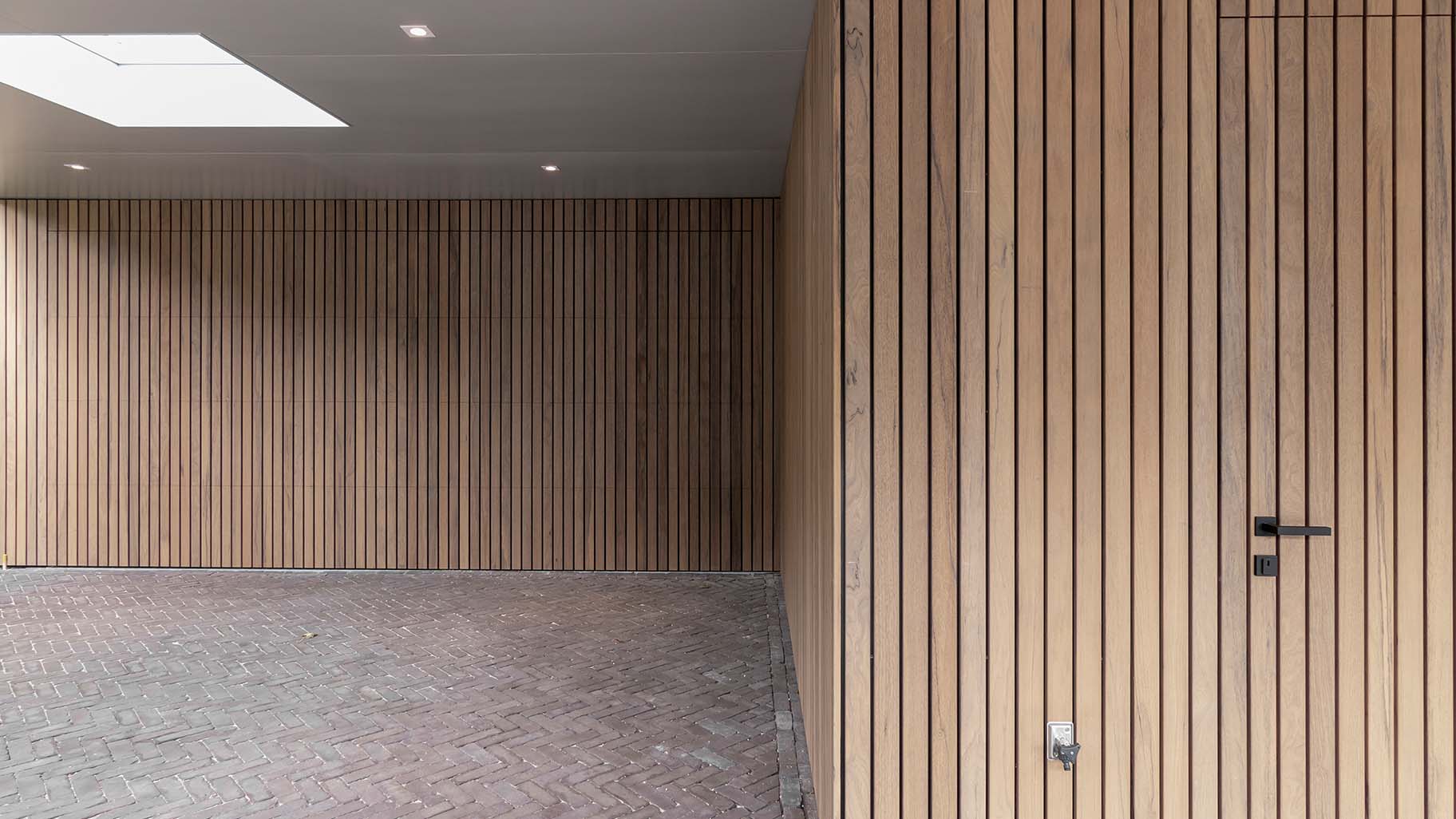 Moderne woning met Frake houten garagedeur en voordeur, passend bij de gevel