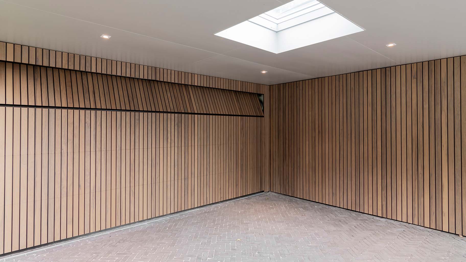 Frake houten garagedeur en voordeur, gelijk met de gevel