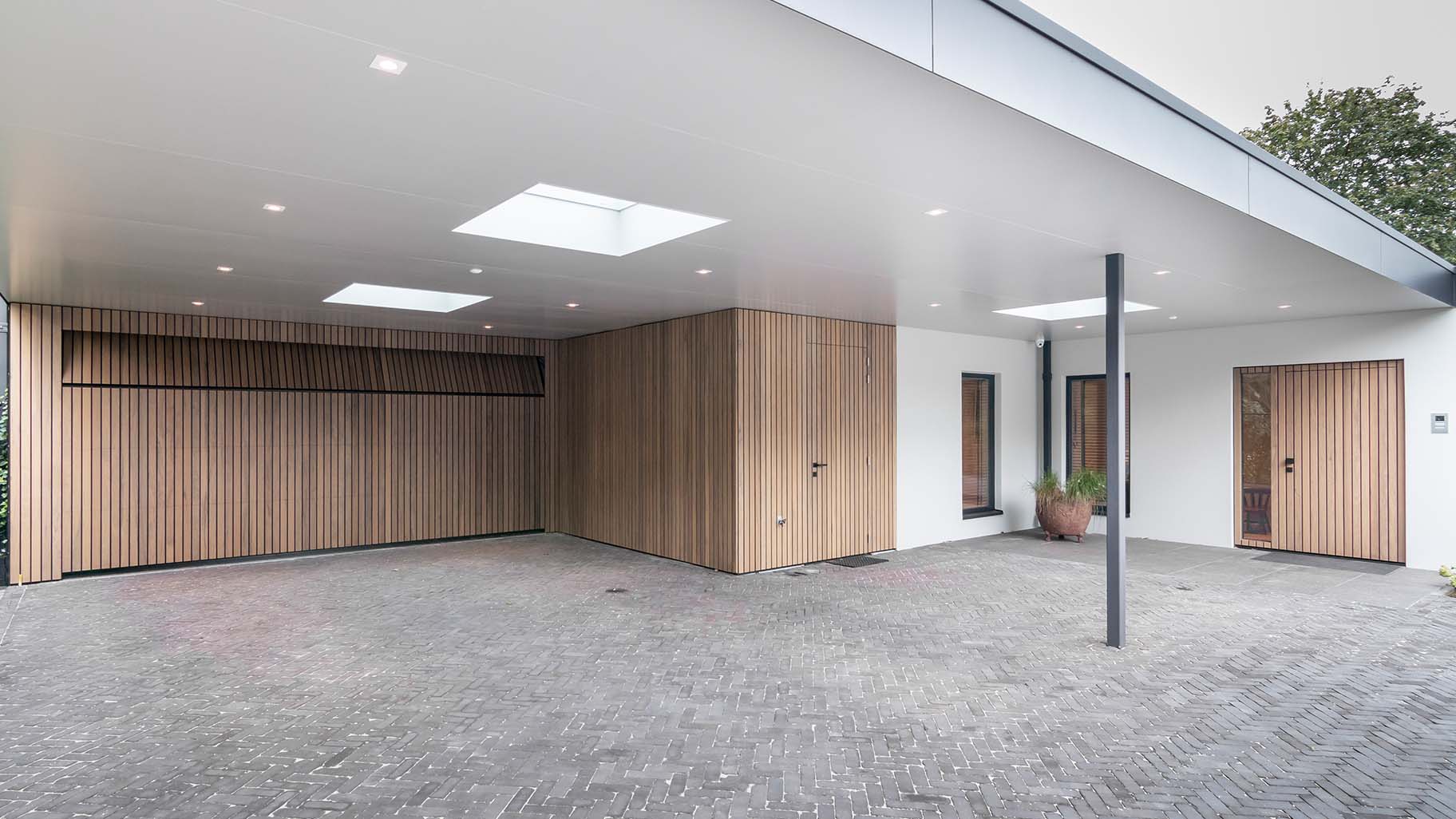 Different Doors garagedeur en voordeur van Frake hout, geïntegreerd in moderne gevel