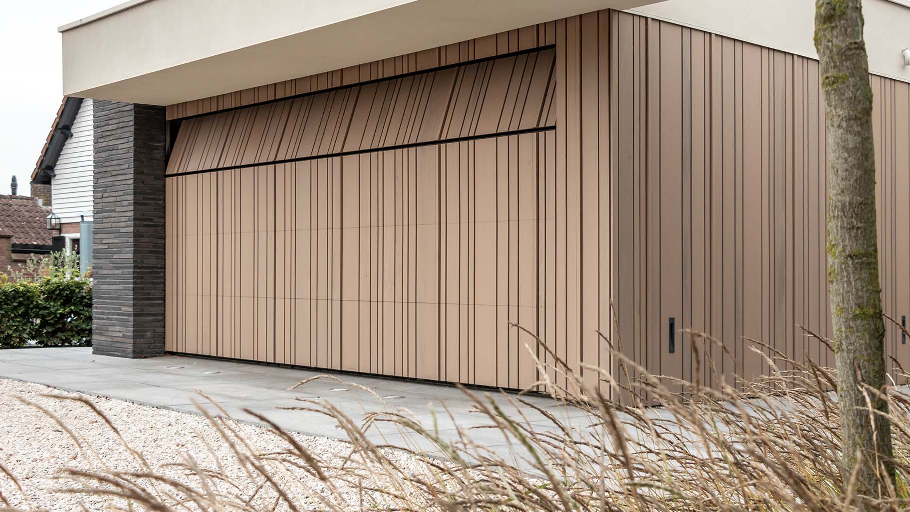 Houten garagedeur met verticale latten die gelijk met de gevel is geplaatst