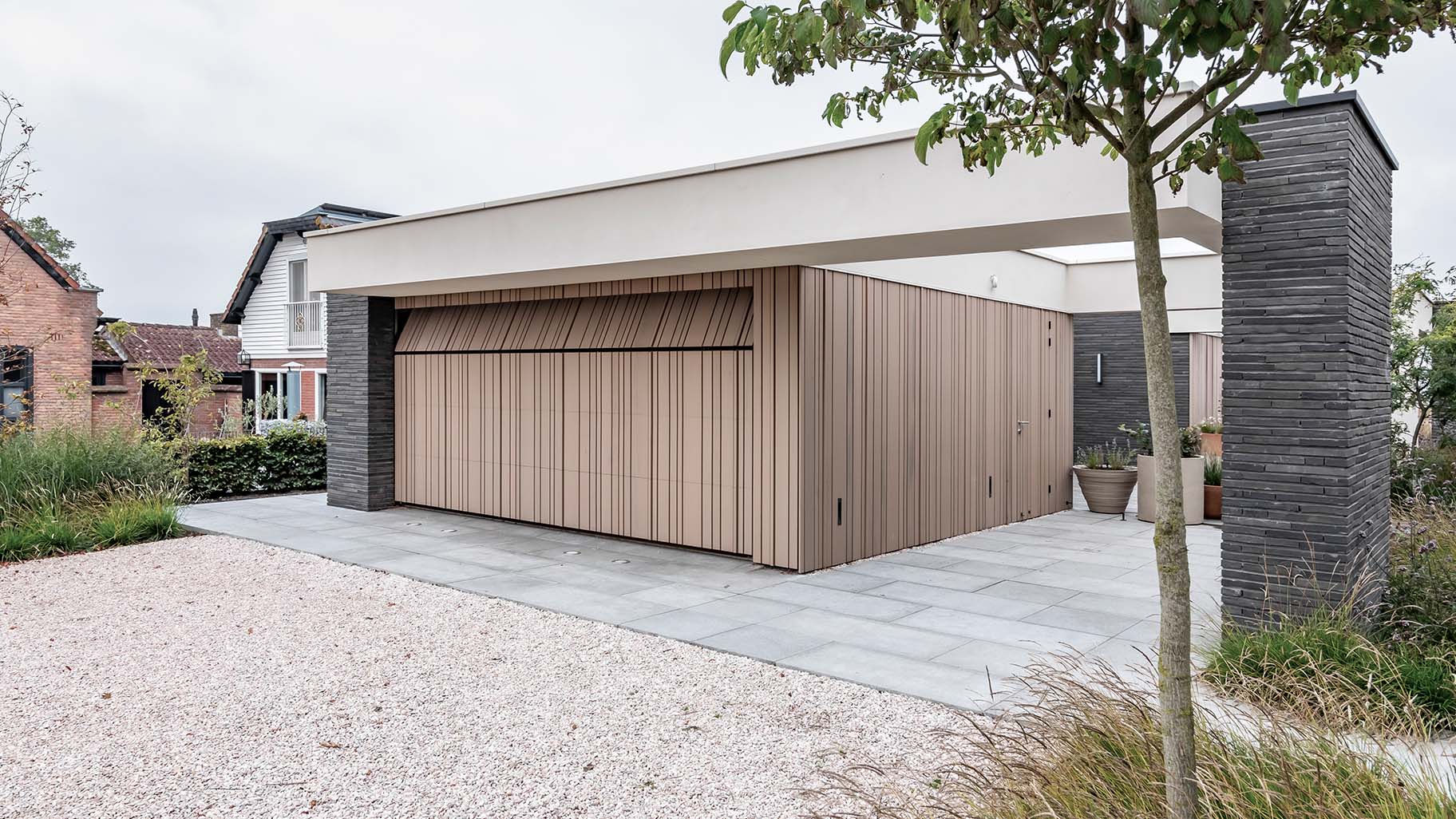 Moderne nieuwbouwwoning met een houten sectionaaldeur die onzichtbaar opgaat in de gevel