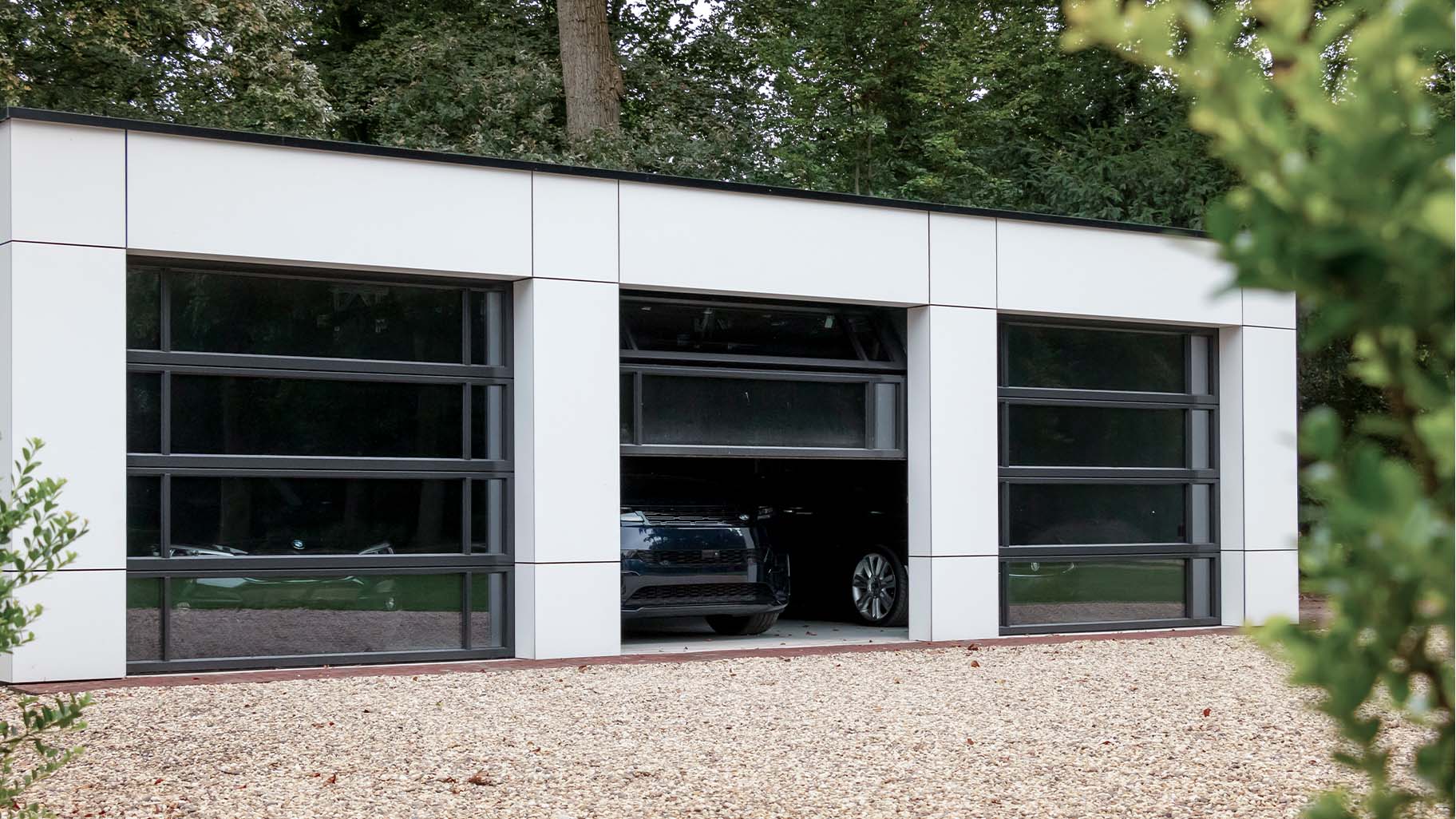 Garage met drie identieke glazen garagedeuren mooi in de gevel