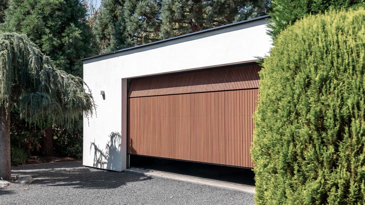Houten garagedeur achter de dag bij moderne woning - Different Doors