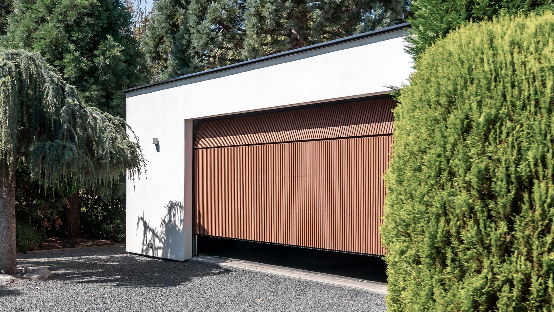 Houten garagedeur achter de dag bij moderne woning - Different Doors