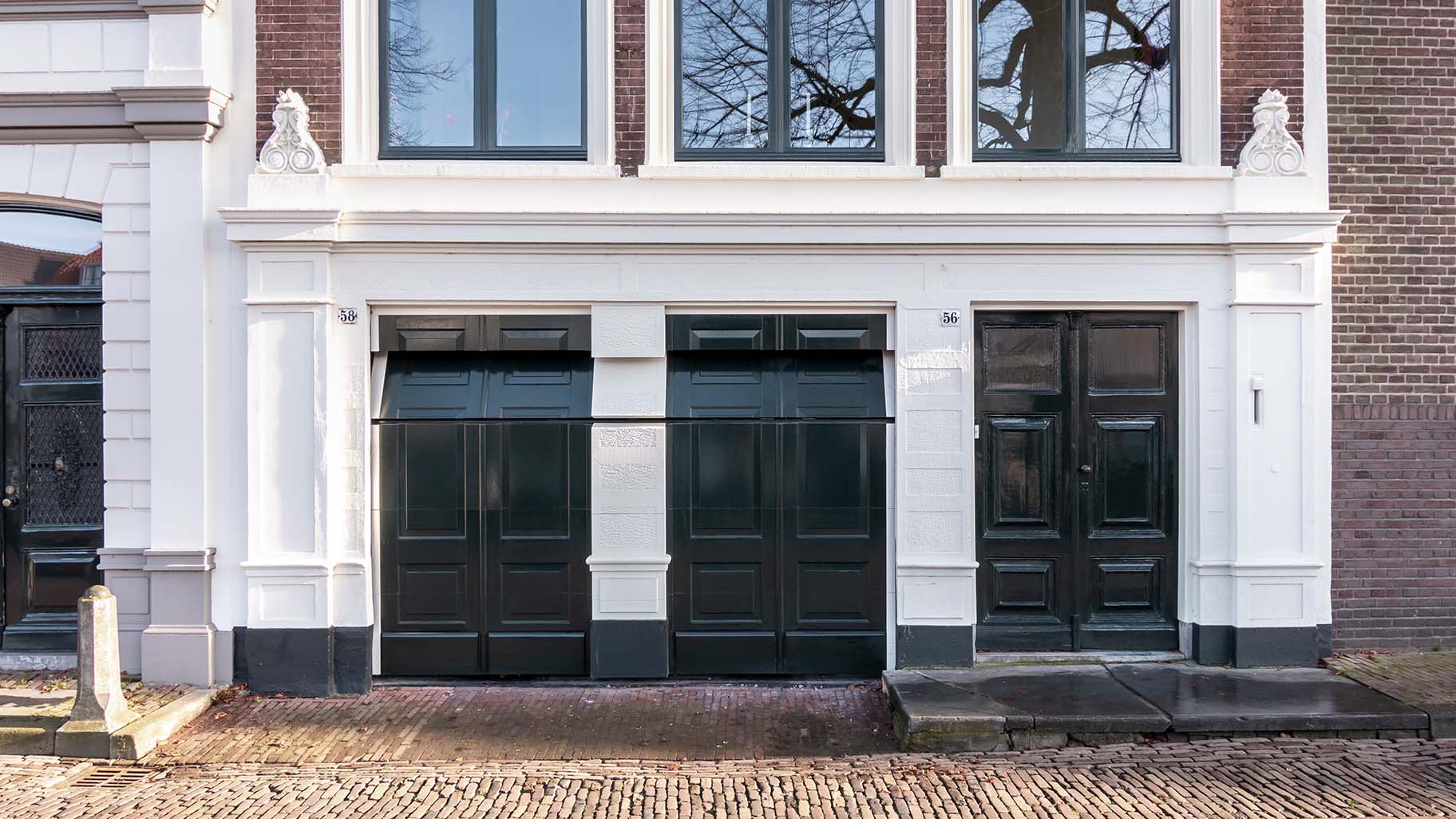 Onzichtbare houten garagedeur volledig geïntegreerd in de gevel van monumentaal pand in Gorinchem