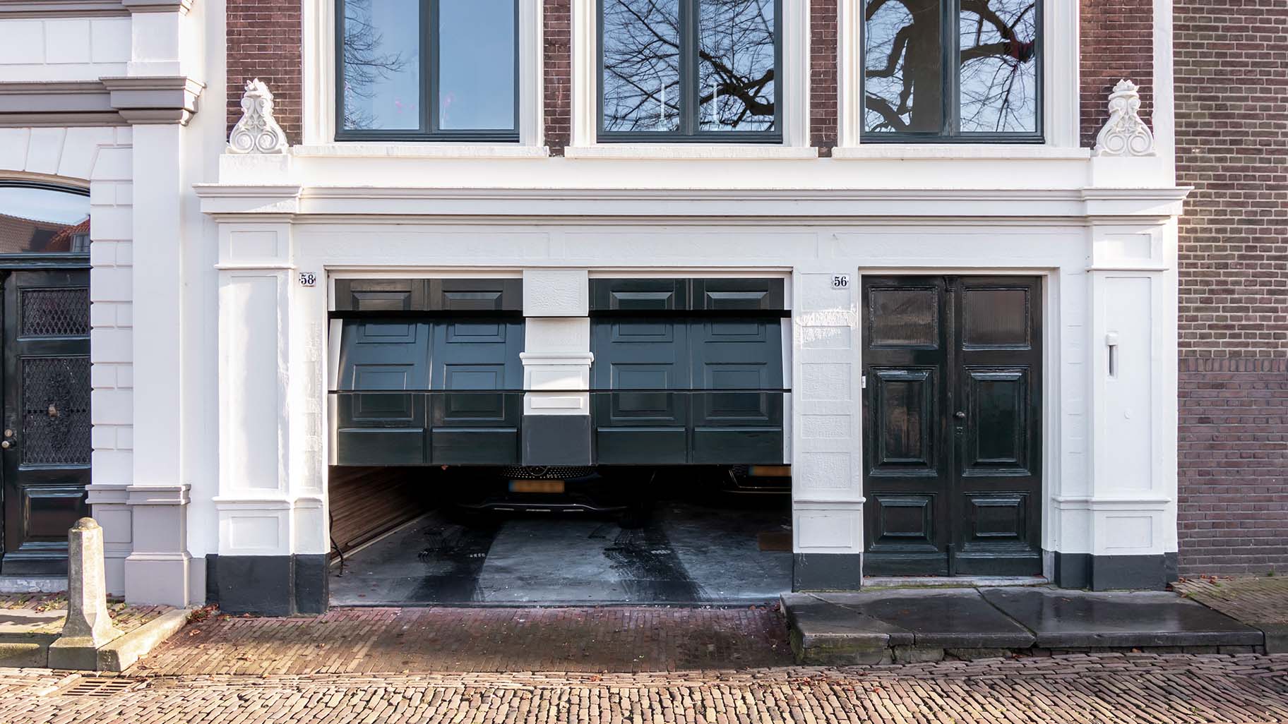 Onzichtbare houten garagedeur volledig geïntegreerd in de gevel van monumentaal pand in Gorinchem