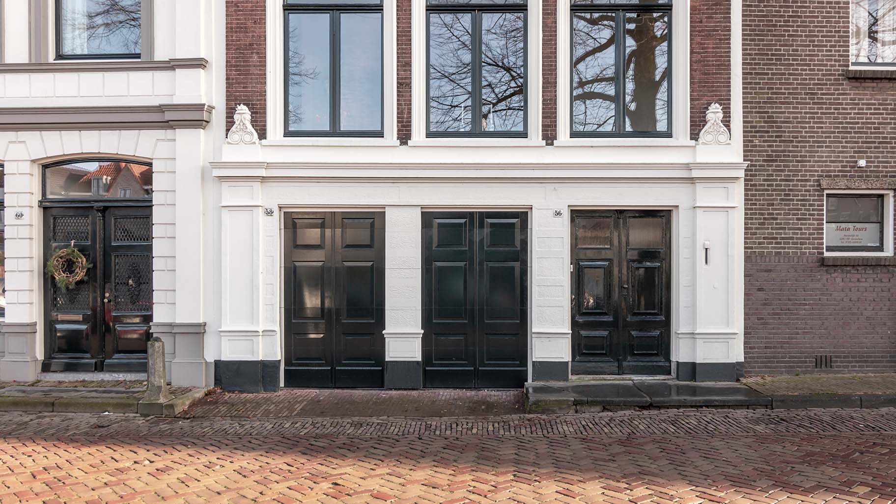 Monumentaal pand in Gorinchem met authentieke houten garagedeur die de historische uitstraling behoudt.