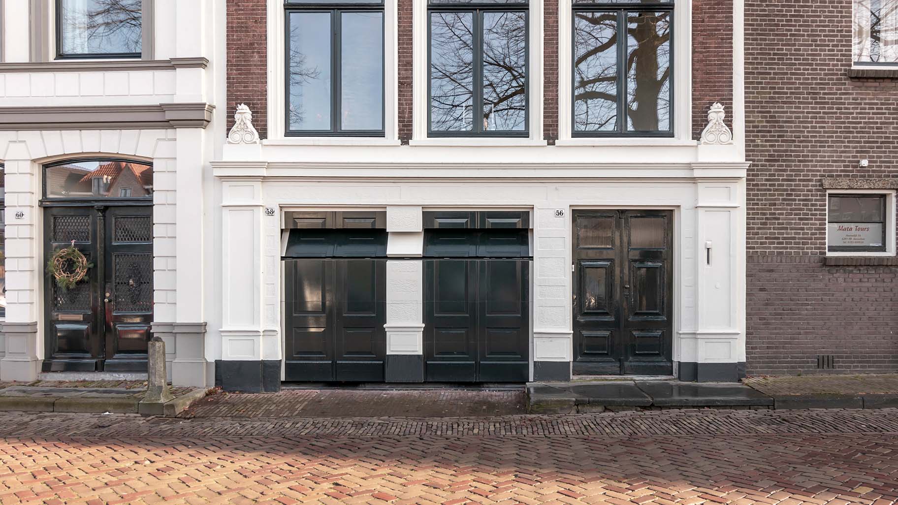 Monumentaal pand in Gorinchem met authentieke houten garagedeur die de historische uitstraling behoudt.