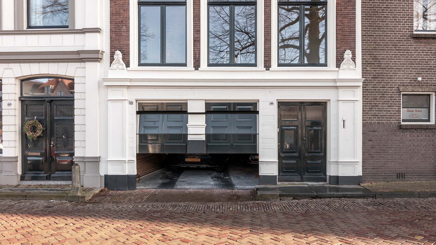 Monumentaal pand in Gorinchem met authentieke houten garagedeur die de historische uitstraling behoudt.