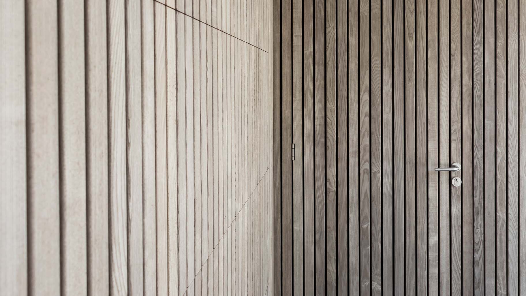 Detail van vergrijsd Essen hout in garagedeur en gevel