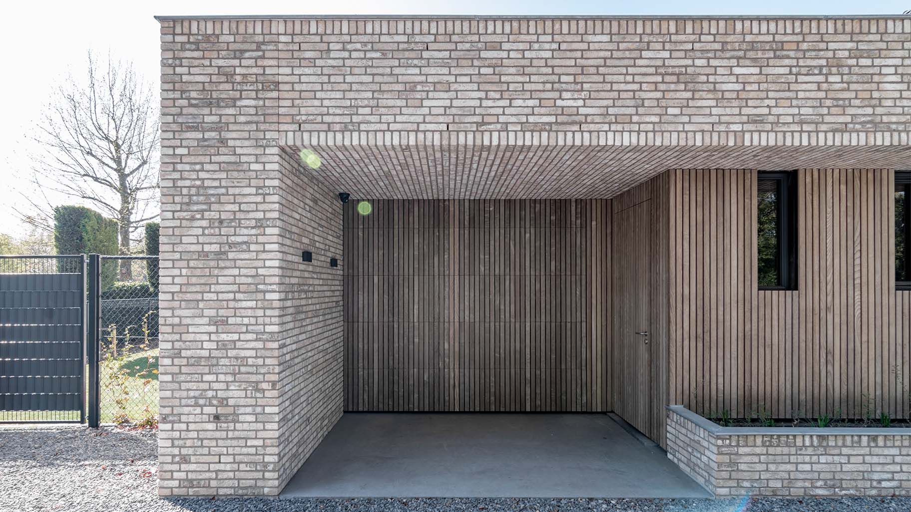 Houten garagedeur en gevel in vergrijsd Essen, gemaakt door Different Doors