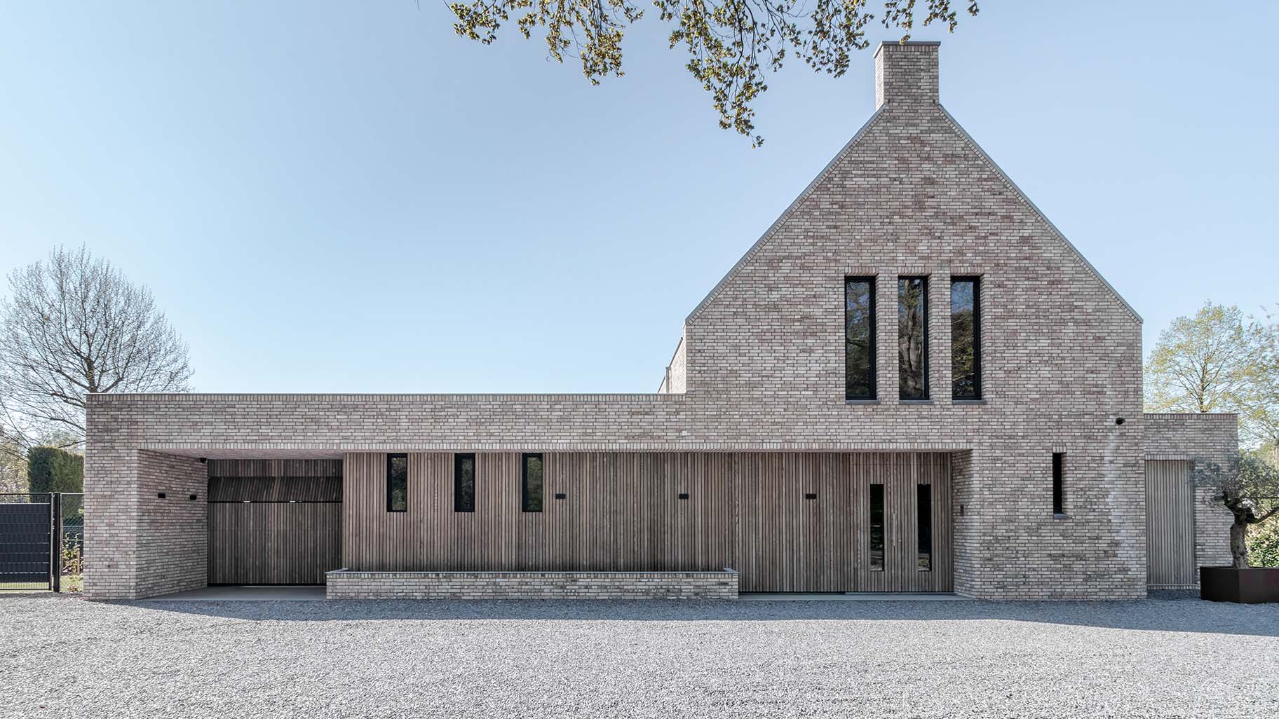 Moderne villa met houten garagedeur en gevelbekleding in vergrijsd Essen hout