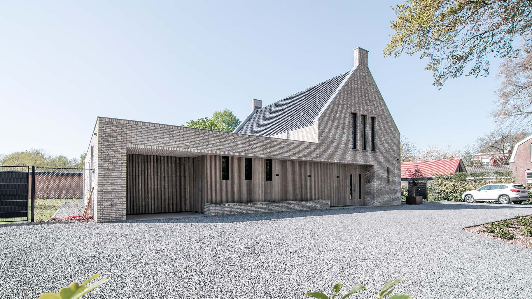 Onzichtbare houten garagedeur geïntegreerd in de gevel, gerealiseerd door Different Doors