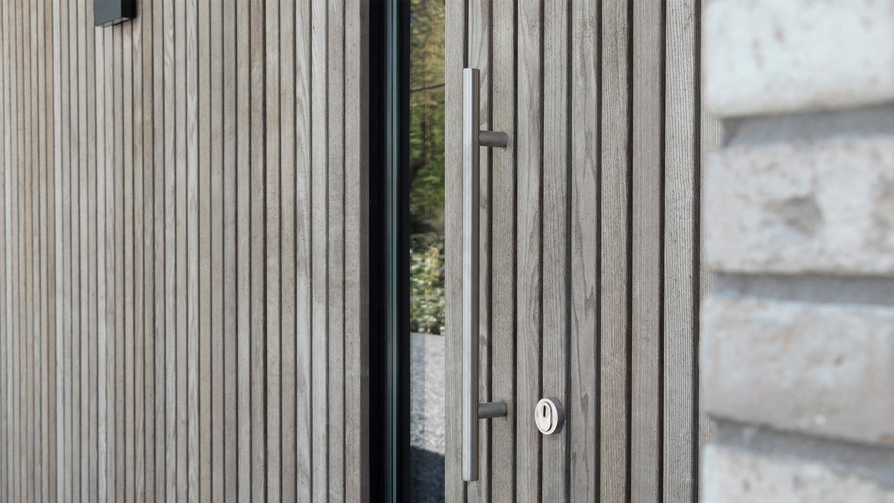 Detail van vergrijsd Essen hout in garagedeur en gevel