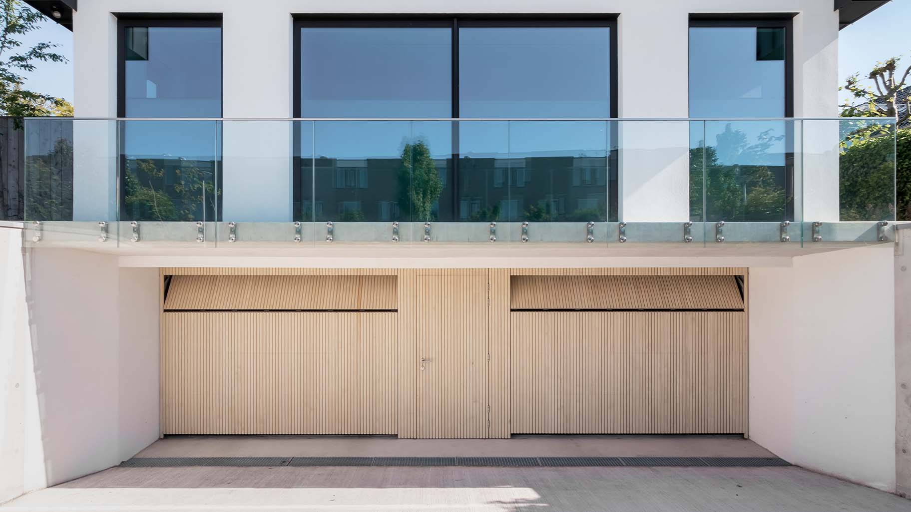 Houten sectionaaldeuren met loopdeur van Accoya hout gemaakt door Different Doors