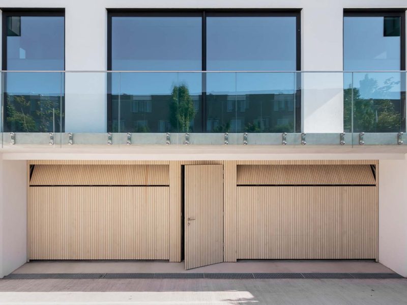 Houten sectionaaldeuren met loopdeur van Accoya hout gemaakt door Different Doors