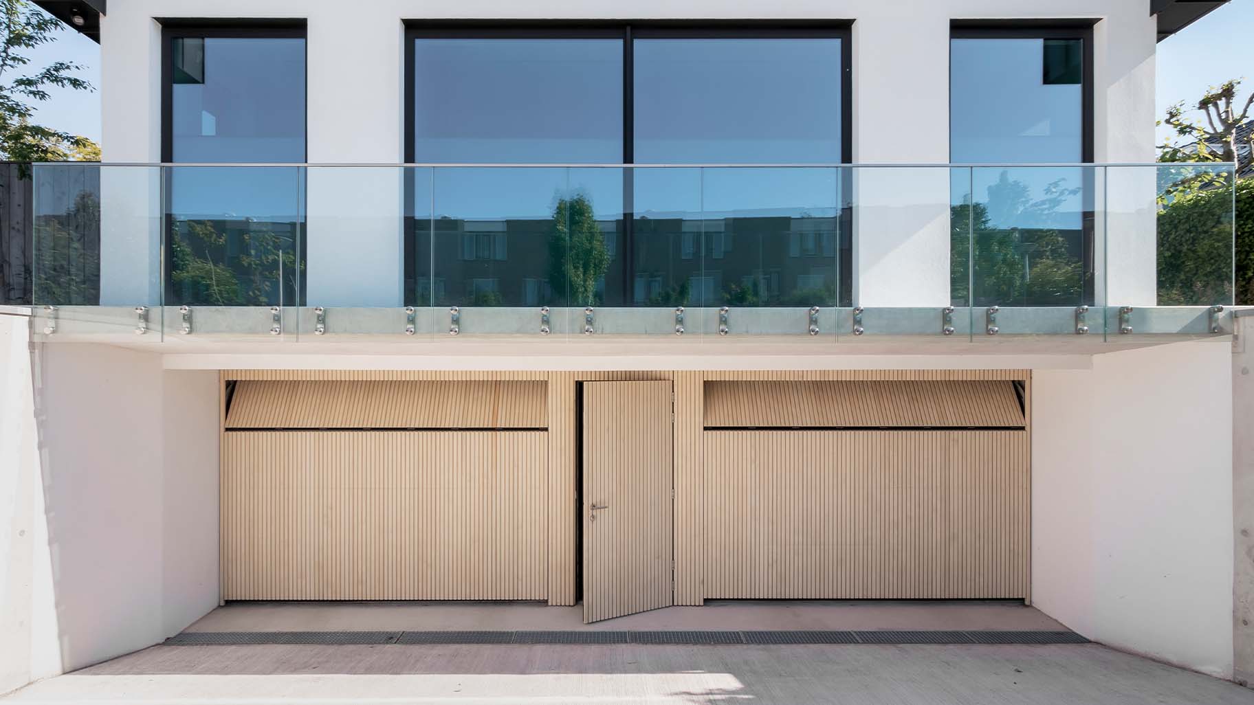 Houten sectionaaldeuren met loopdeur van Accoya hout gemaakt door Different Doors